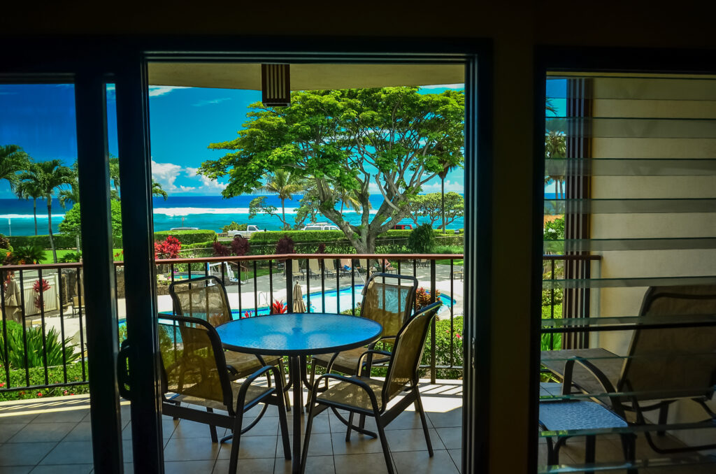 View from a balcony overlooking a tropical garden, pool, and ocean, ideal for exploring Hawaii and enjoying Hawaii travel on a budget